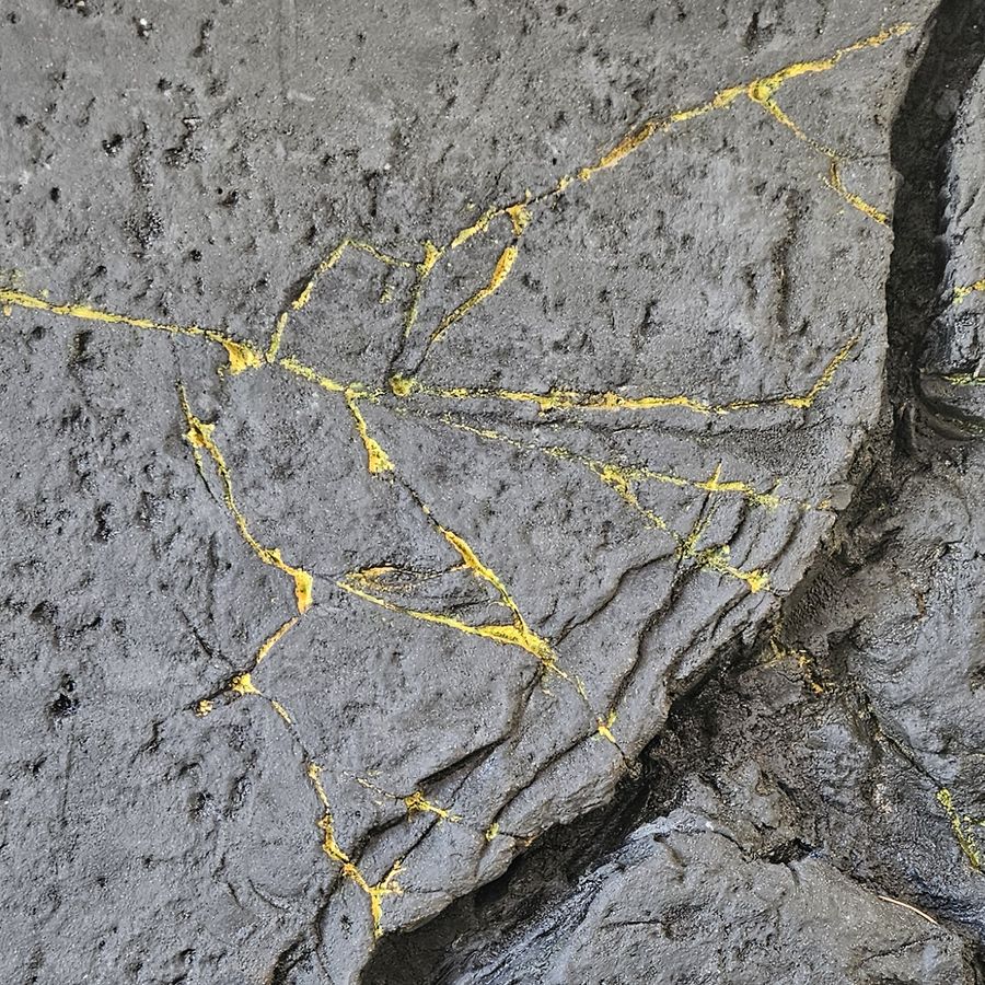 Parement mural effet roche noire veinée d'or sculpté à la main, noir volcanique et veines dorées