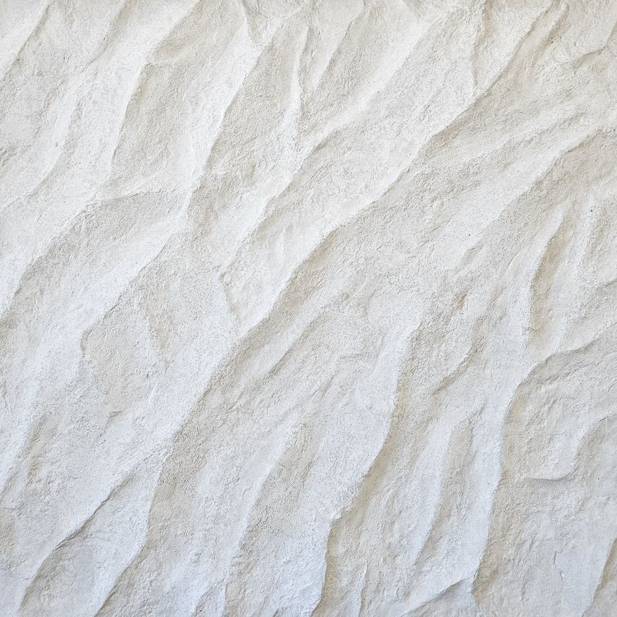 Parement mural effet travertin blanc sculpté à la main, ondulations douces et teinte crayeuse