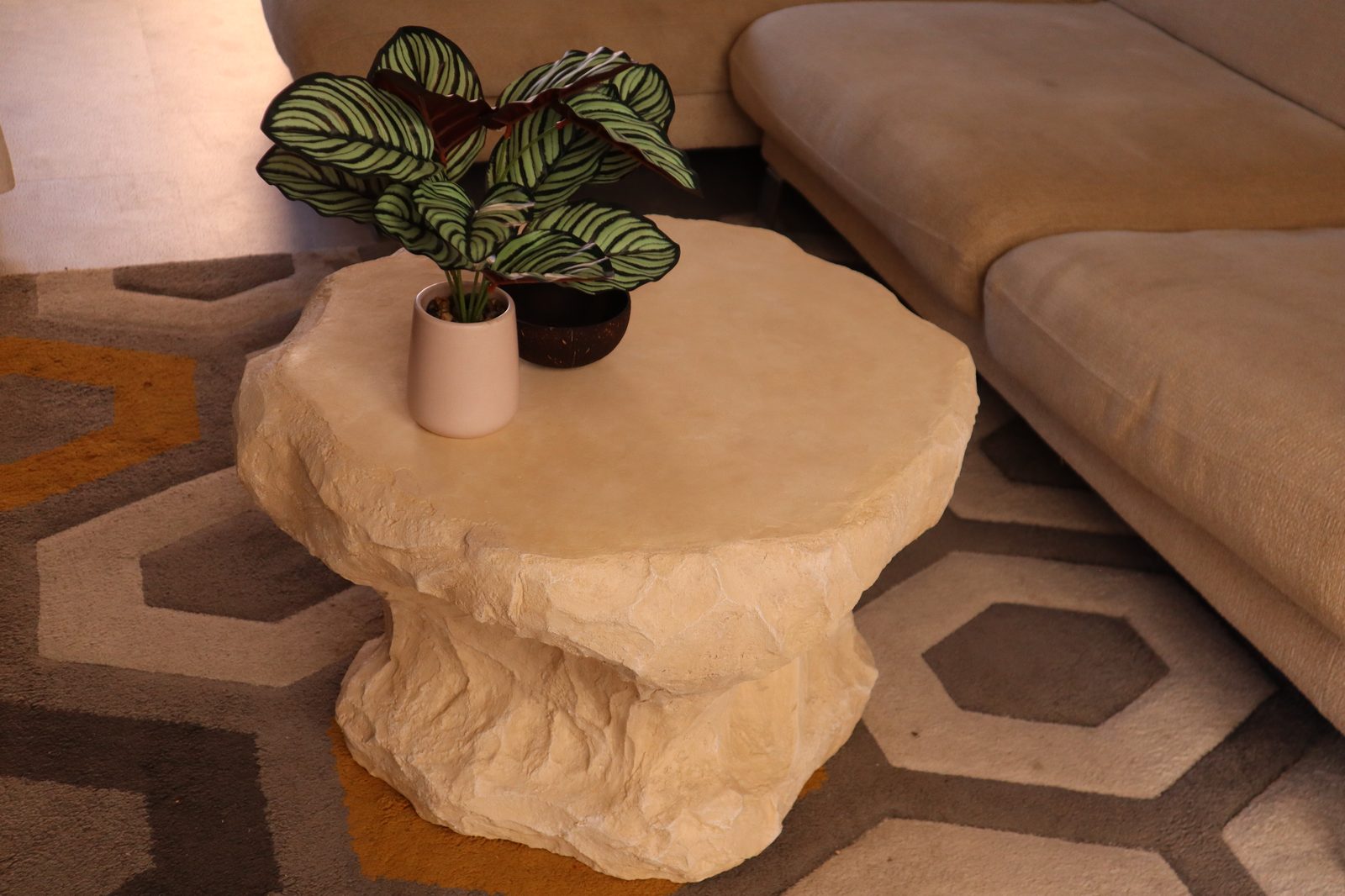 Table d'appoint effet travertin, roche claire sculptée à la main, plateau rond et flancs taillés
