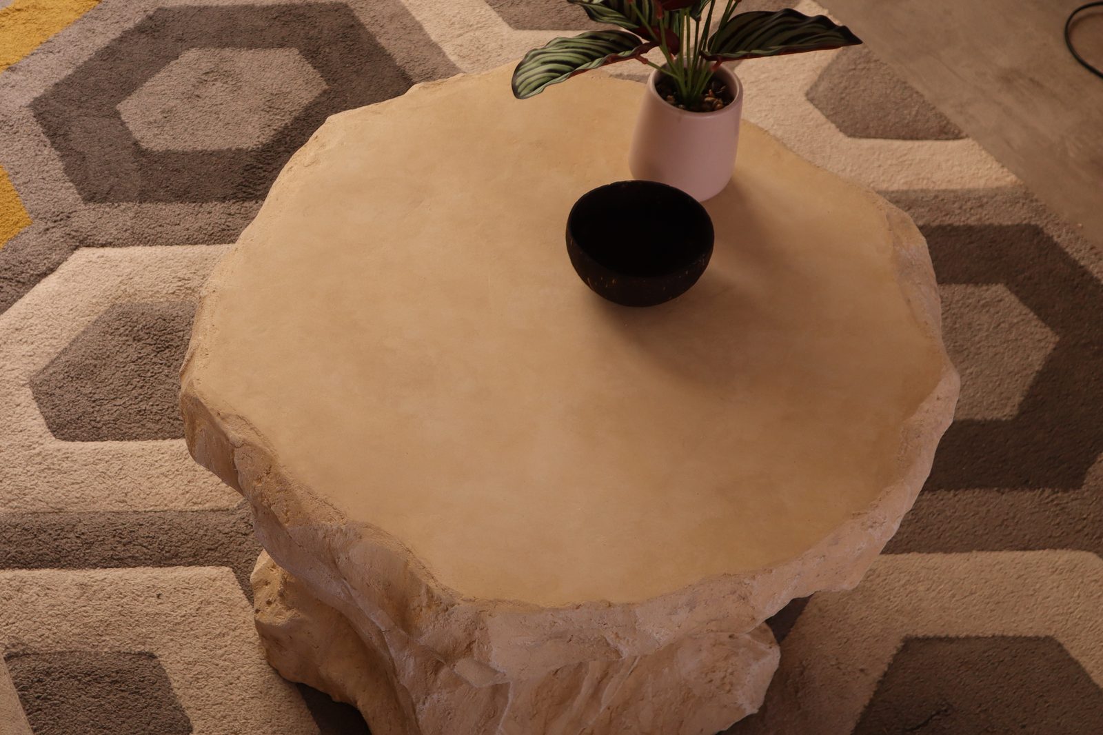 Plateau de la table d'appoint vu de dessus, surface lisse effet travertin et bord sculpté à vif
